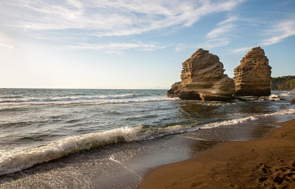 una spiaggia con due grandi rocce nell'oceano di Hotel Celeste a Procida