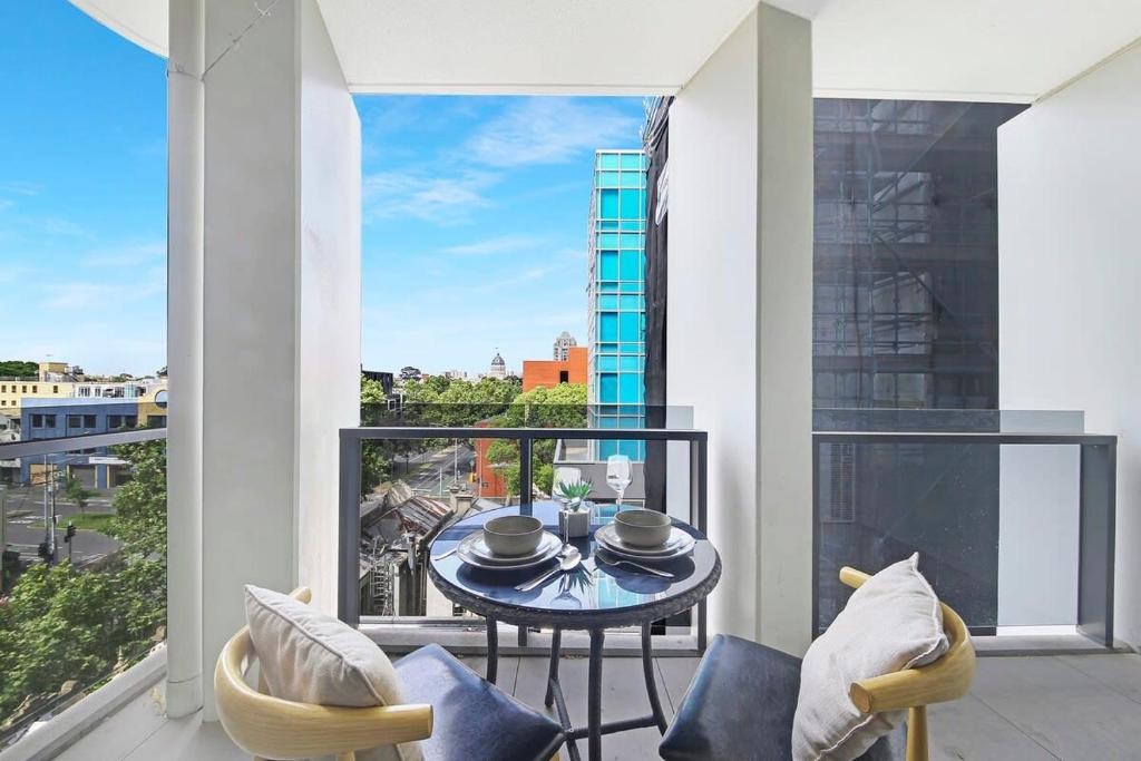 balkon ze stołem i krzesłami oraz widokiem na miasto w obiekcie A Stylish & Cozy 2BR Apt Near Melbourne Central w Melbourne