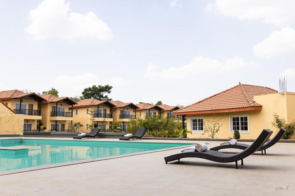 un complejo con una piscina con sillas enfrente en The Fern Wisteria Resort, Dhari, en Dhāri
