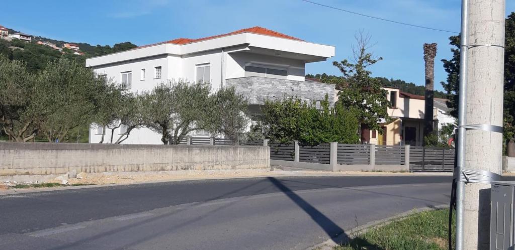 a house on the side of a street with a fence at Apartmani Marković RAB in Palit
