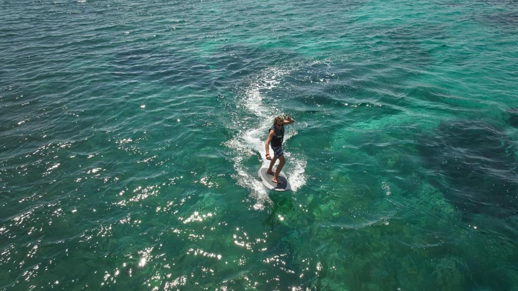 a person riding a surfboard in the water at Inmood Aucanada 4 Sup in Port d'Alcudia