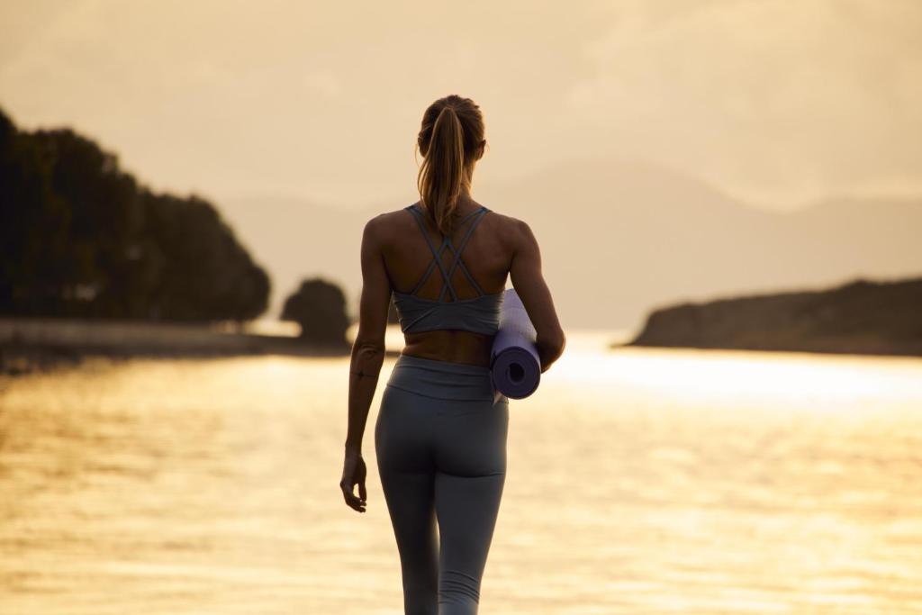 a woman walking on the beach with a camera at Inmood Aucanada 4 Sup in Port d'Alcudia