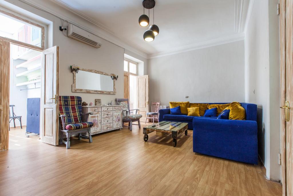 a living room with a blue couch and chairs at Sweet Home at Rustaveli Avenue in Tbilisi City