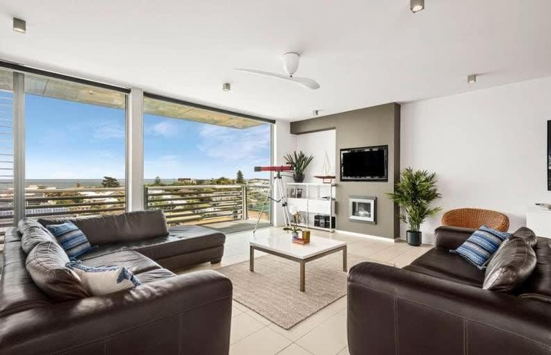 ein Wohnzimmer mit 2 Sofas und einem großen Fenster in der Unterkunft Penthouse apartment with breathtaking sea views in Ocean Grove