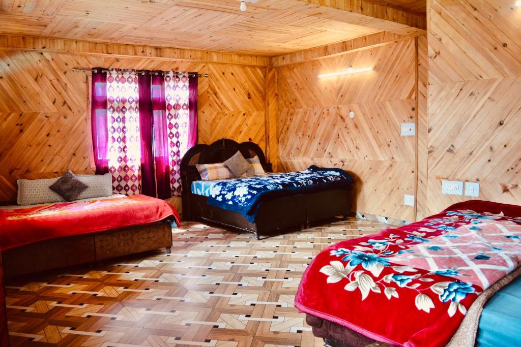 een slaapkamer met 2 bedden in een houten kamer bij Pahadi Bliss Hostel ,Tosh in Tosh