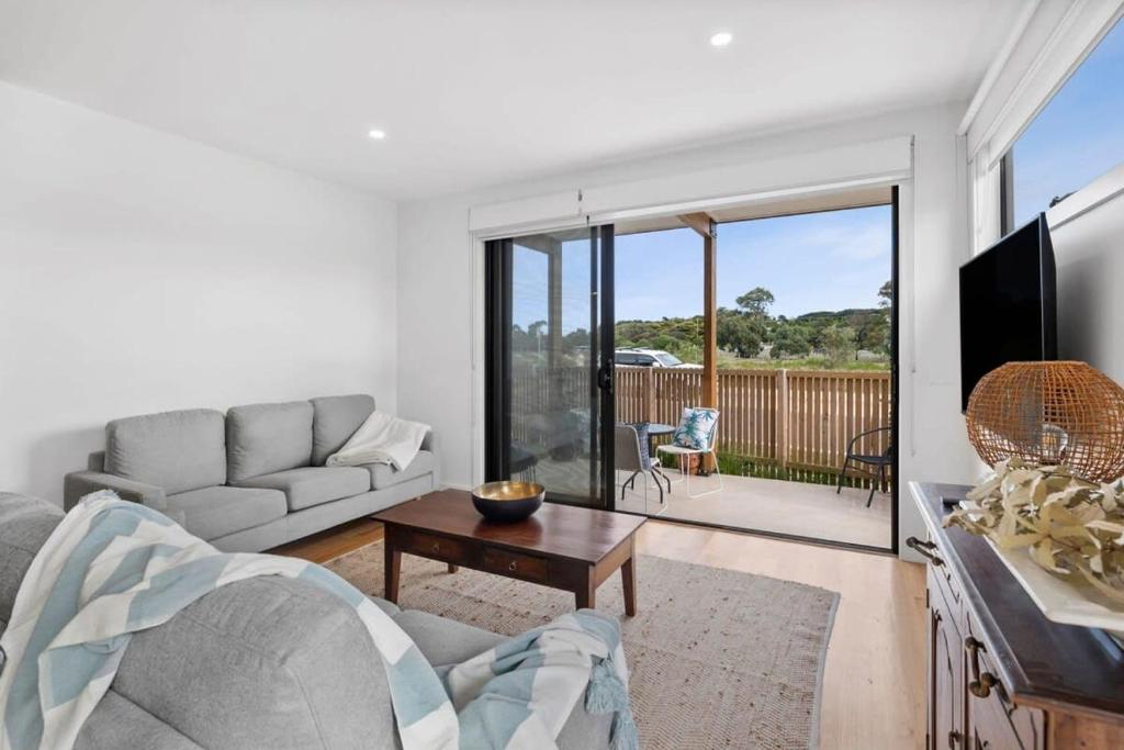 a living room with a couch and a table at Boardwalk on Bright Coastal Apartment in Torquay