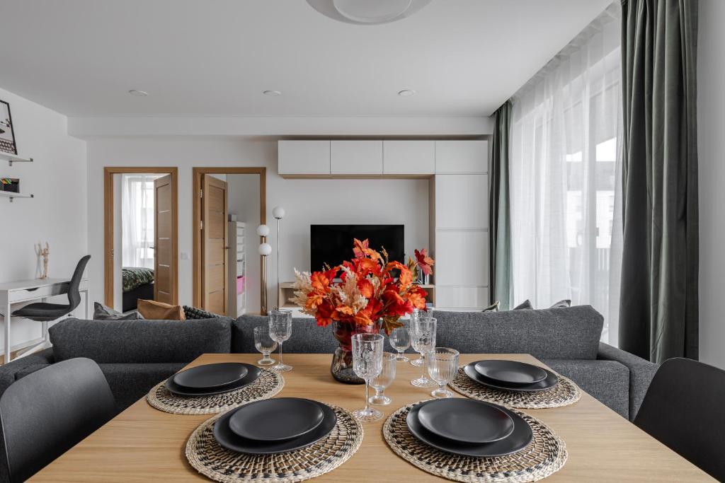 a dining room with a wooden table with a vase of flowers at Fantasy House, cozzy apartmens, free parking, long stays welcome in Vilnius