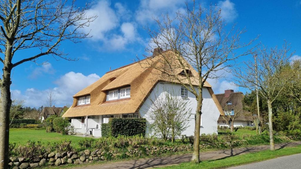 a white house with a thatched roof at Hochstieg 2 Nieblum Whg 7 in Nieblum