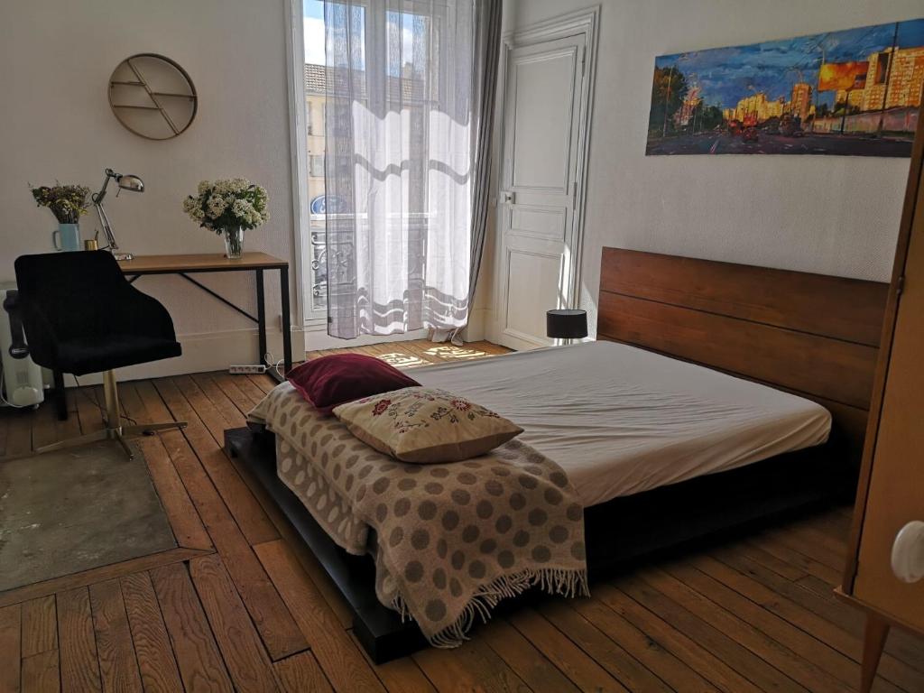 Schlafzimmer mit einem Bett, einem Schreibtisch und einem Fenster in der Unterkunft Lumière & Majesté Appartement Versailles in Versailles
