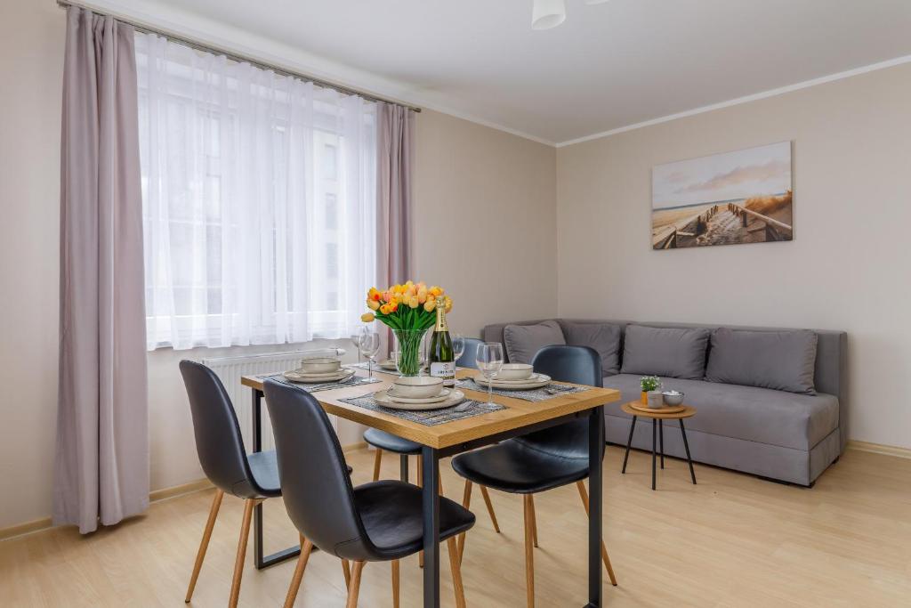 a living room with a table and chairs and a couch at Apartment Nautilus Swinoujscie Promenade by Renters in Świnoujście