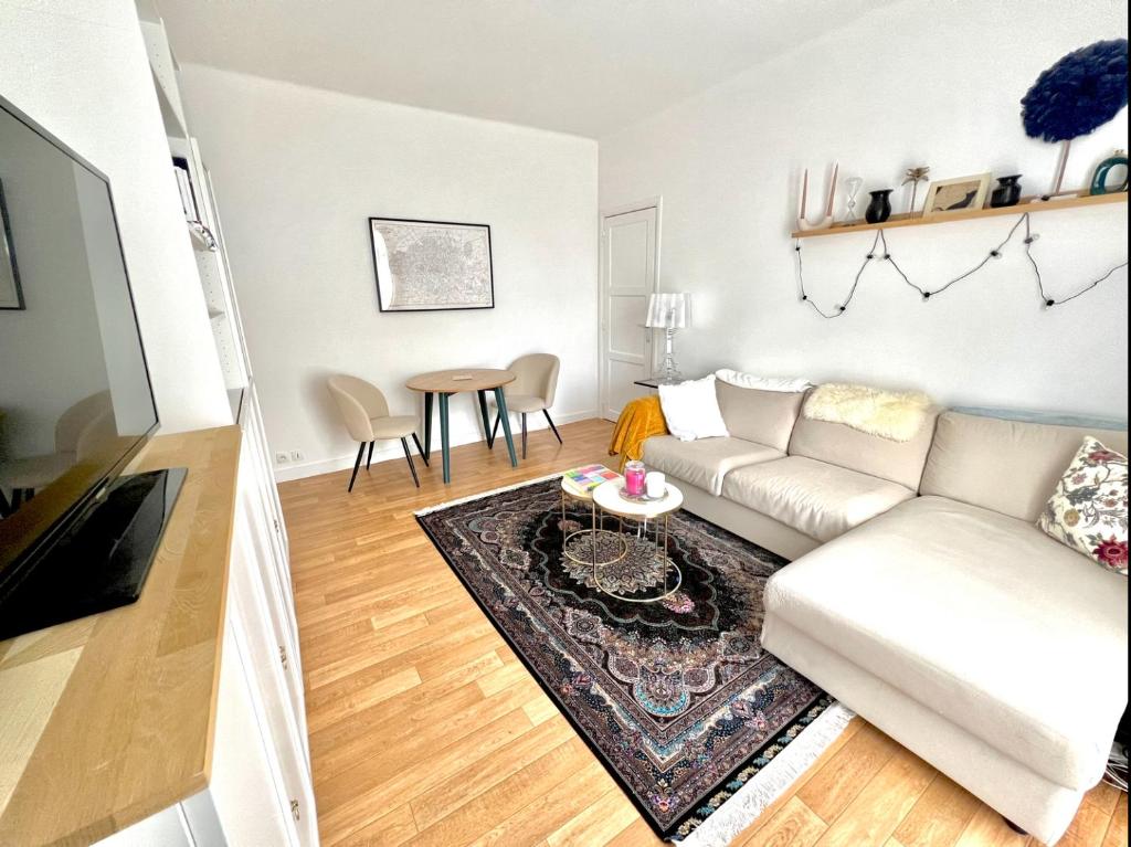 Apartment near to Paris (7 minutes) في أسنيير-سور-سين: غرفة معيشة مع أريكة بيضاء وطاولة