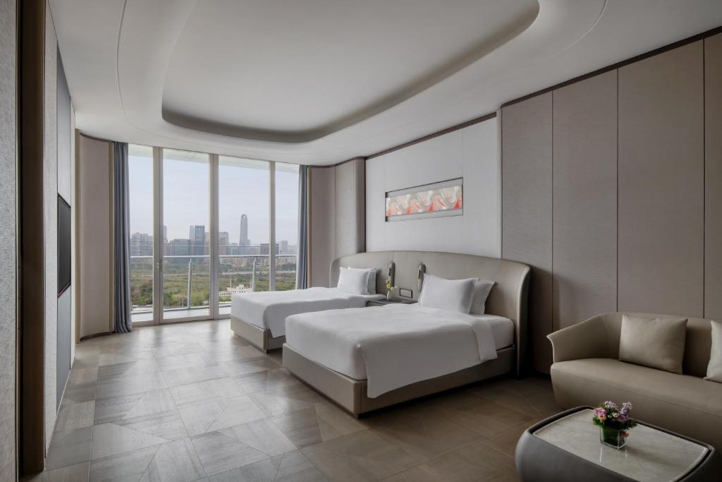 a hotel room with two beds and a couch at Vignette Collection The Xanadu Guangzhou, an IHG Hotel - -Free Canton Fair Shuttle Bus and Registration Counter in Guangzhou
