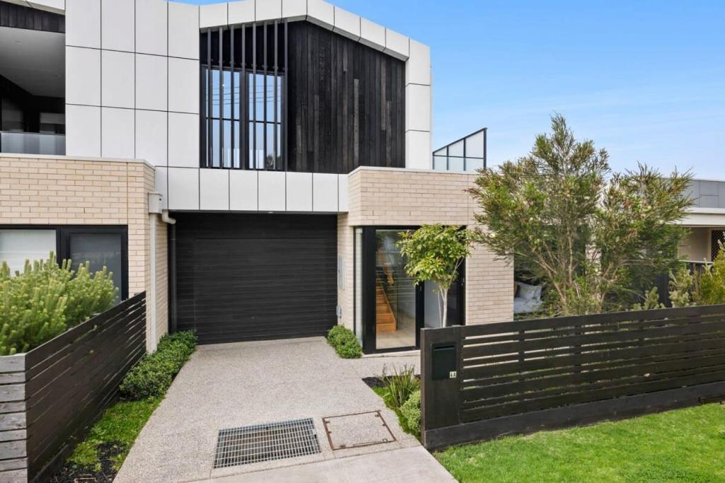 a brick house with a black garage at Torquay Central Beach Retreat in Torquay