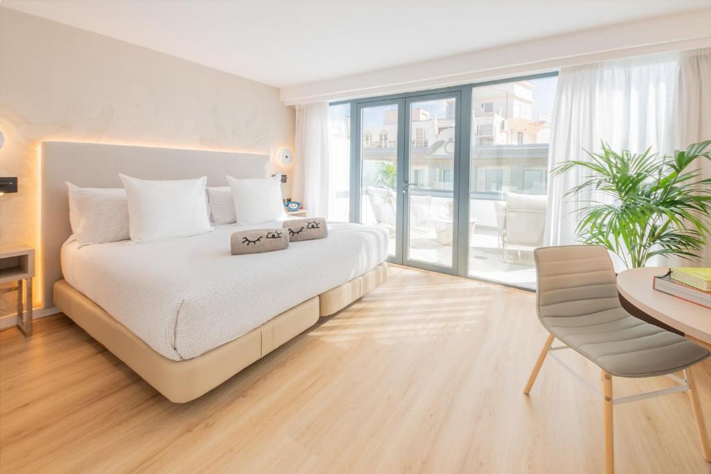 a bedroom with a white bed and a table and a chair at INNSiDE by Meliá Tenerife Santa Cruz in Santa Cruz de Tenerife
