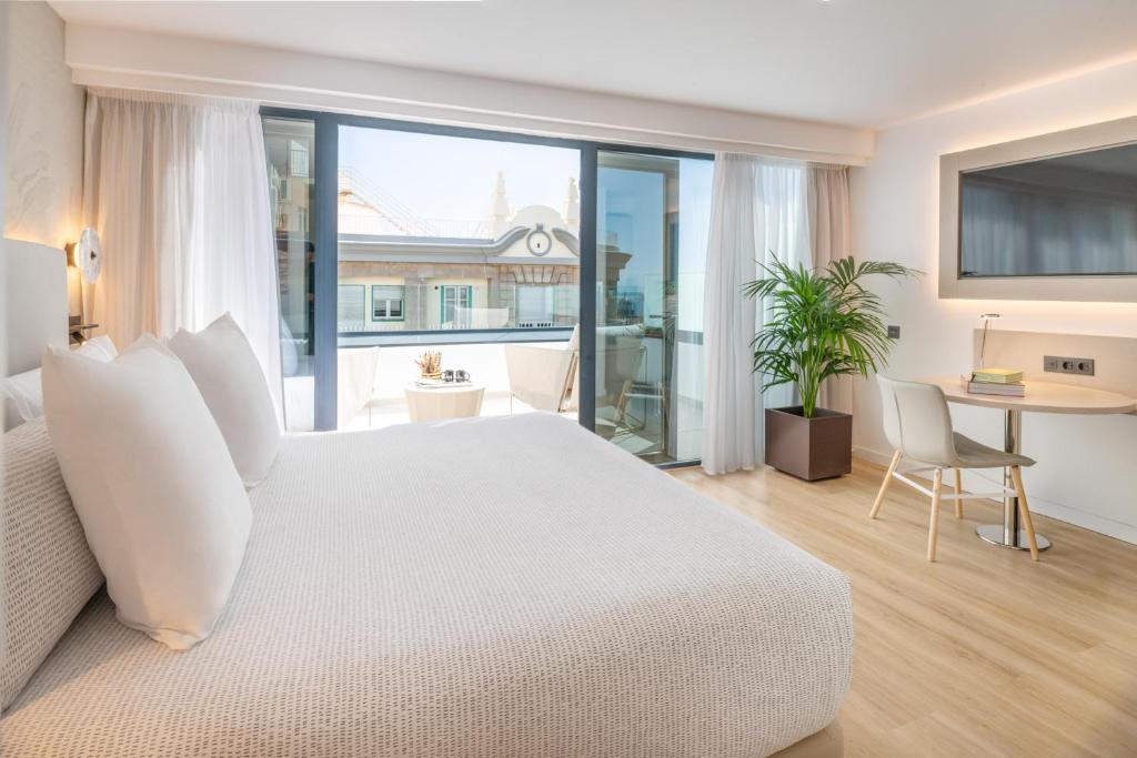 a bedroom with a white bed and a large window at INNSiDE by Meliá Tenerife Santa Cruz in Santa Cruz de Tenerife