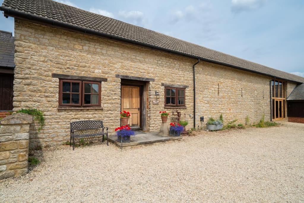 a brick building with a bench in front of it at The Granary self-catering cottage on a working farm in Buckinghamshire