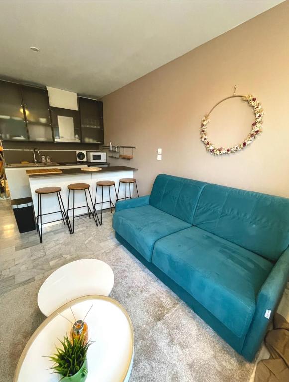 un salon avec un canapé bleu et une cuisine dans l'établissement T2 à 50m de la mer, à Bormes-les-Mimosas