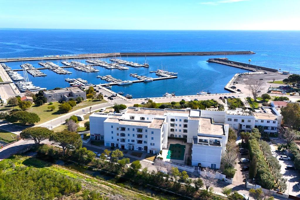 una vista aérea de un puerto deportivo con barcos en el agua en Le Residenze Blu Sardinia, en La Caletta