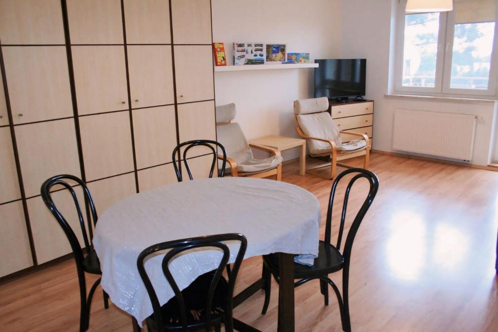 uma sala de jantar com uma mesa e cadeiras e uma televisão em Apartament Rodzinny em Bydgoszcz