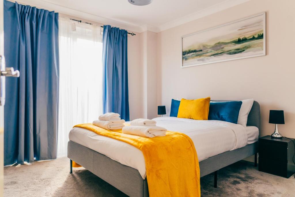 a bedroom with a large bed with blue curtains at Remarkable 4-Bed House in Cardiff in Cardiff