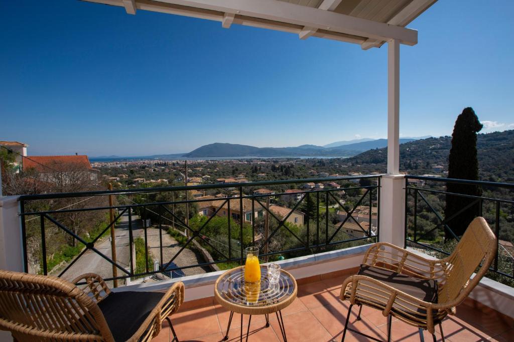 a balcony with a table and chairs and a view at Skyview Suites in Lefkada