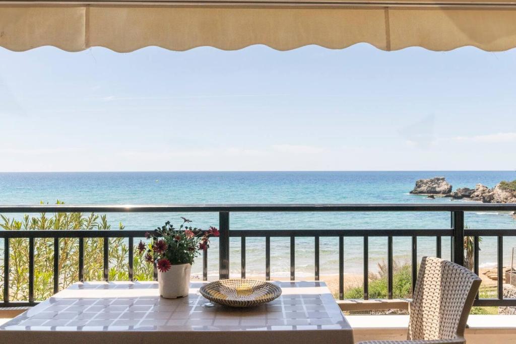 una mesa en un balcón con vistas al océano en Beachfront balcony Marinas Home 2 New Era in Holidays en Glyfada