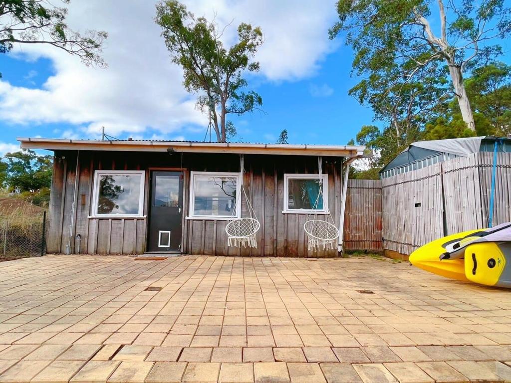 una casa con una valla y un kayak amarillo delante de ella en The Seaside Cottage A little gem by the sea, en Tinderbox