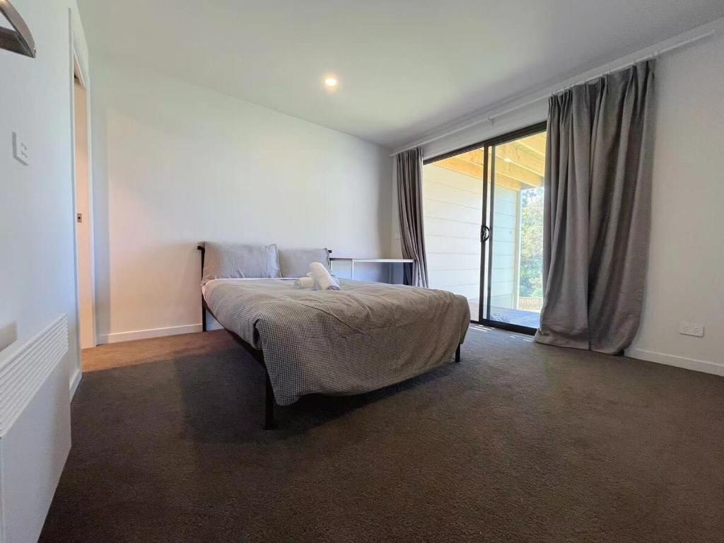 a bedroom with a bed and a large window at 3 bedroom Apartment at Kingston in Kingston