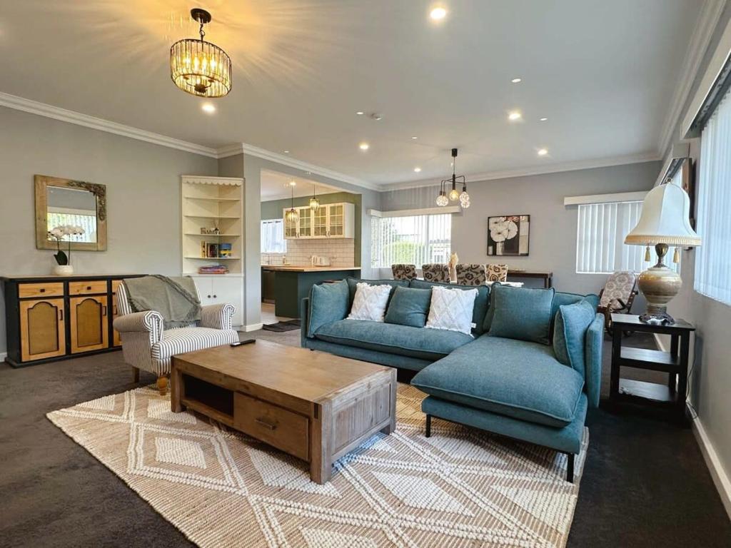 a living room with a blue couch and a table at SandyBay Garden Hideaway in Sandy Bay