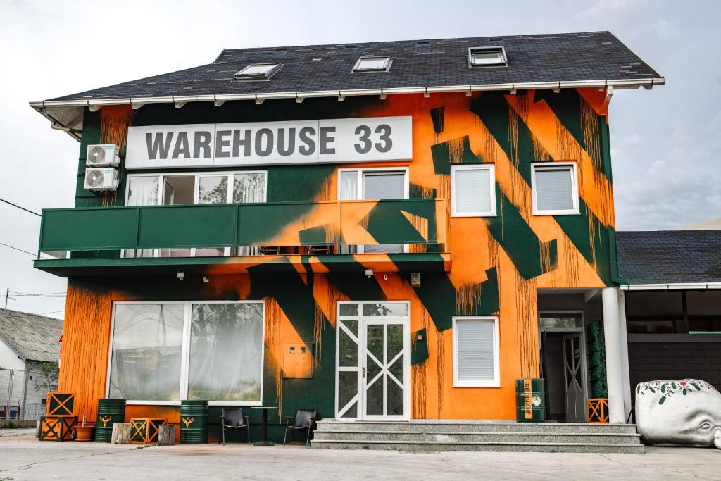 un edificio naranja y verde con un cartel en él en WAREHOUSE 33, en Zagreb
