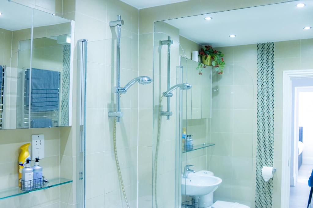 W łazience znajduje się prysznic i umywalka. w obiekcie Stunning-Gated-Listed Stay-Park-Homestay-Retreat w Londynie