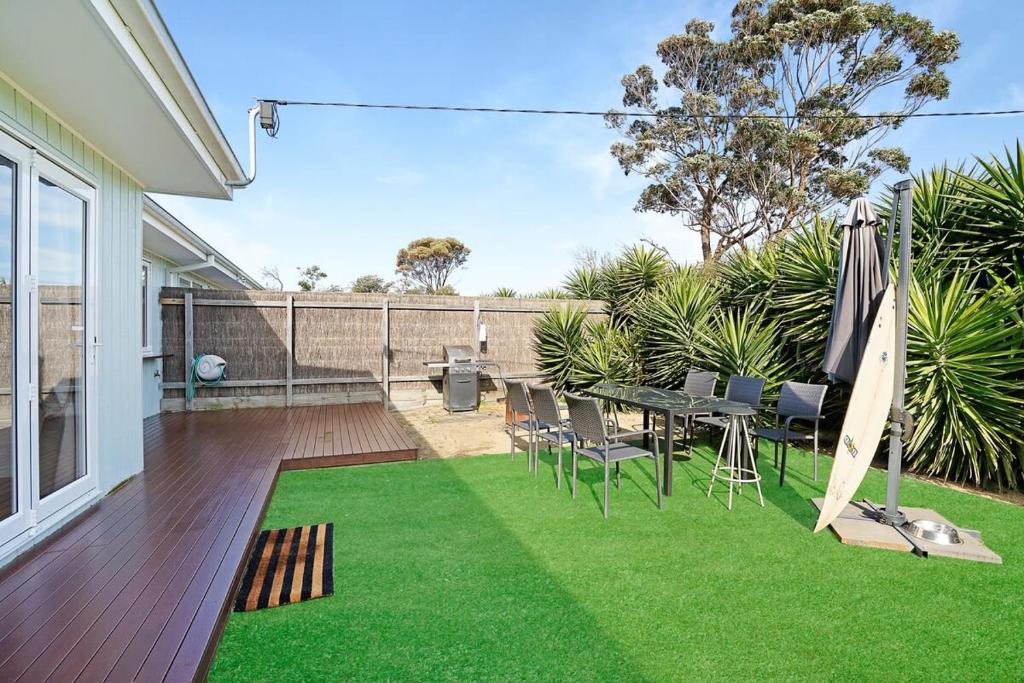a patio with a table and chairs and an umbrella at The Starfish Cottage - 250m to bay beach in Rye
