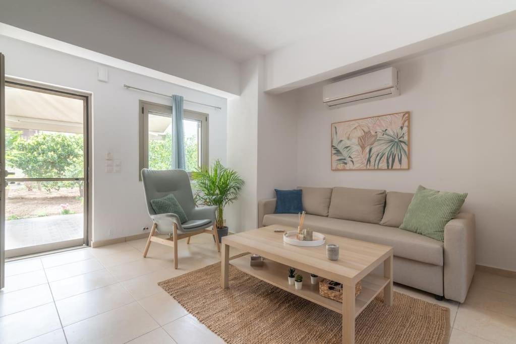 un soggiorno con divano e tavolo di Citrea Stylish House with Garden near Beach a Heraklion
