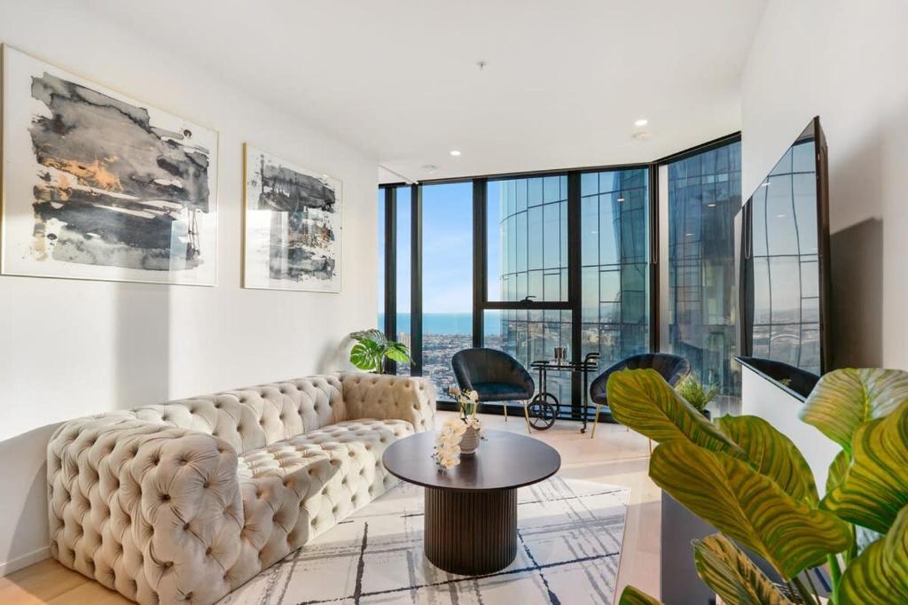een woonkamer met een bank en een tafel bij Southbank Luxury Millennial 2bdm Apt in the Clouds in Melbourne