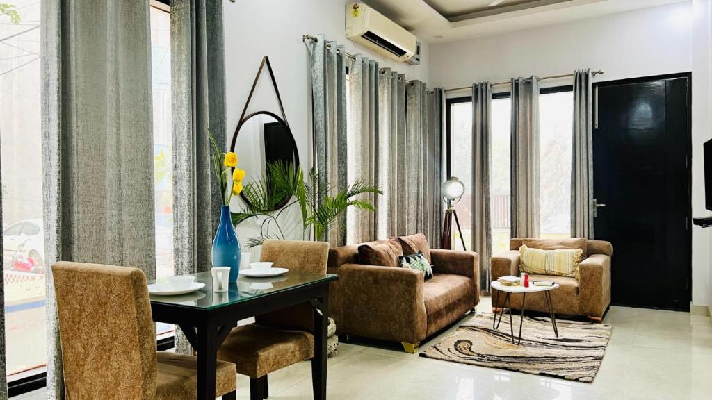 a living room with a table and two chairs and a table sidx sidx at BluO Modern 1BHK - DLF Galleria in Gurgaon