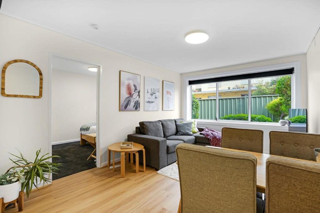 een woonkamer met een bank en een tafel bij Homey 1 bdrm Thornbury Apt near restaurants+shops in Melbourne