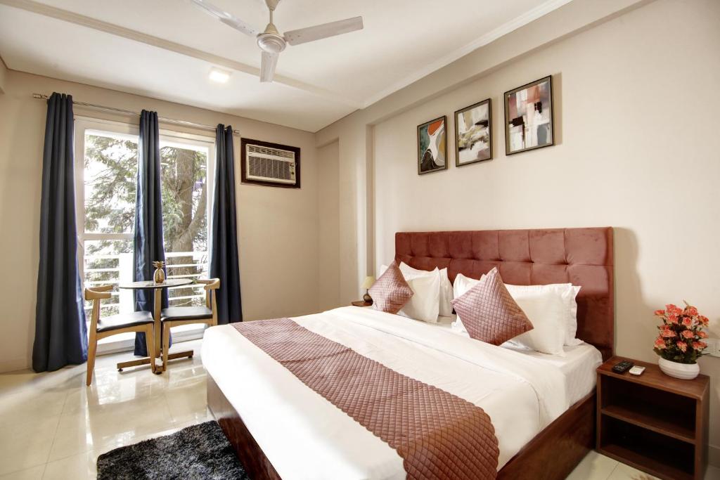 a bedroom with a large bed and a window at Limewood Stay Studio Huda City Center in Gurgaon