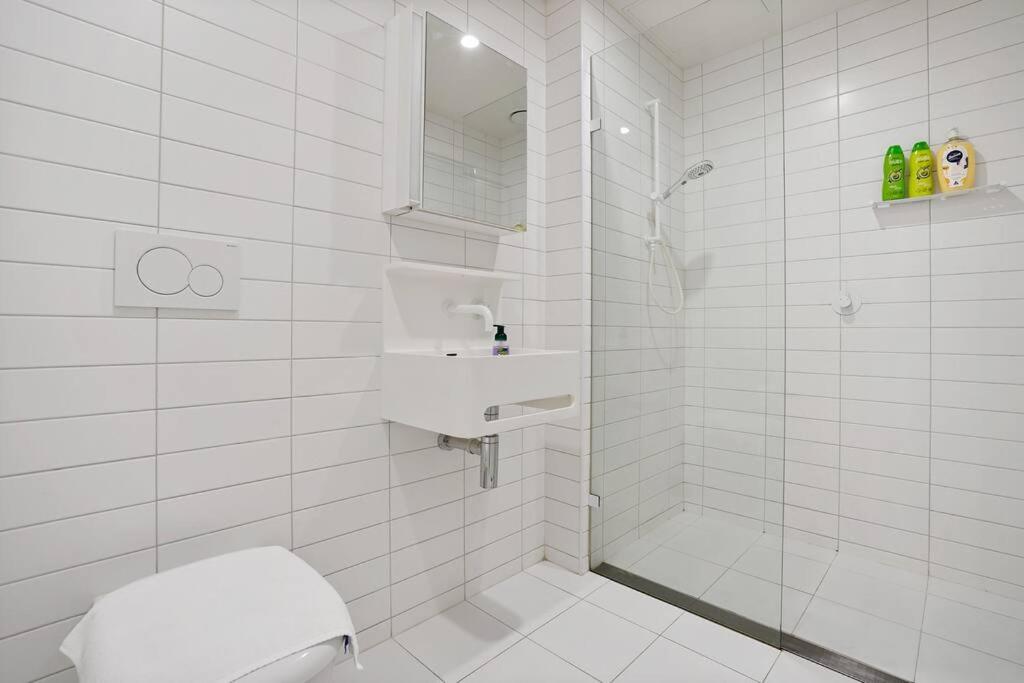 a white bathroom with a toilet and a sink at Lv53 Spanning 200 degrees with no obstacle view421 in Melbourne