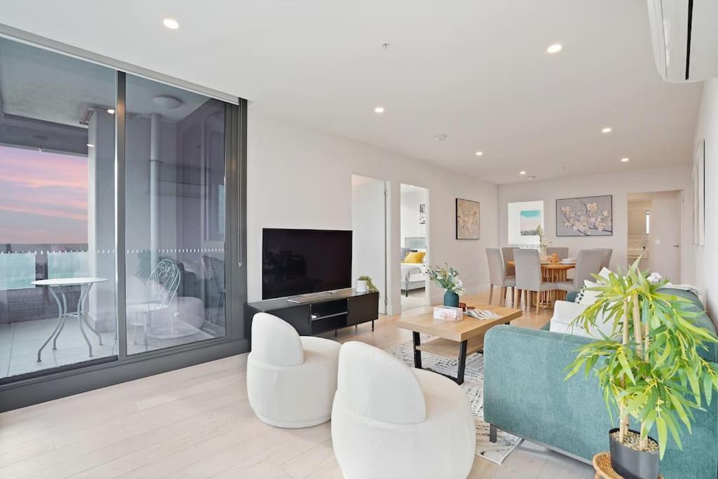 a living room with white furniture and a large window at Lv53 Spanning 200 degrees with no obstacle view421 in Melbourne