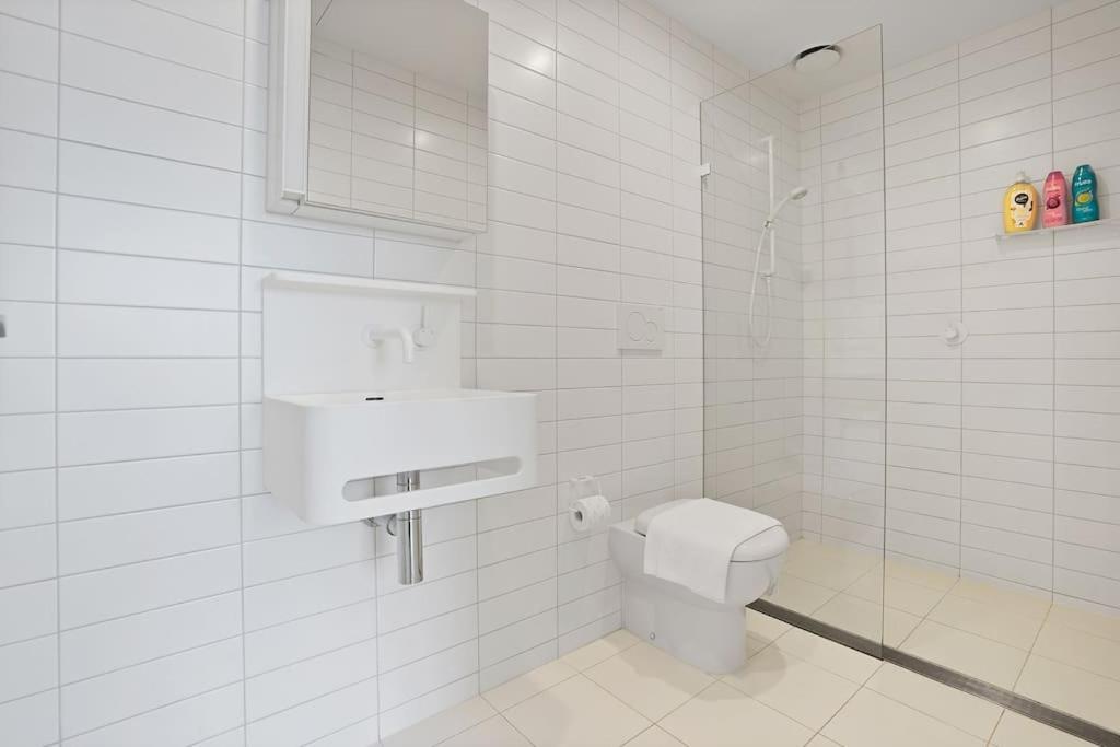 a white bathroom with a toilet and a sink at Lv53 Spanning 200 degrees with no obstacle view421 in Melbourne