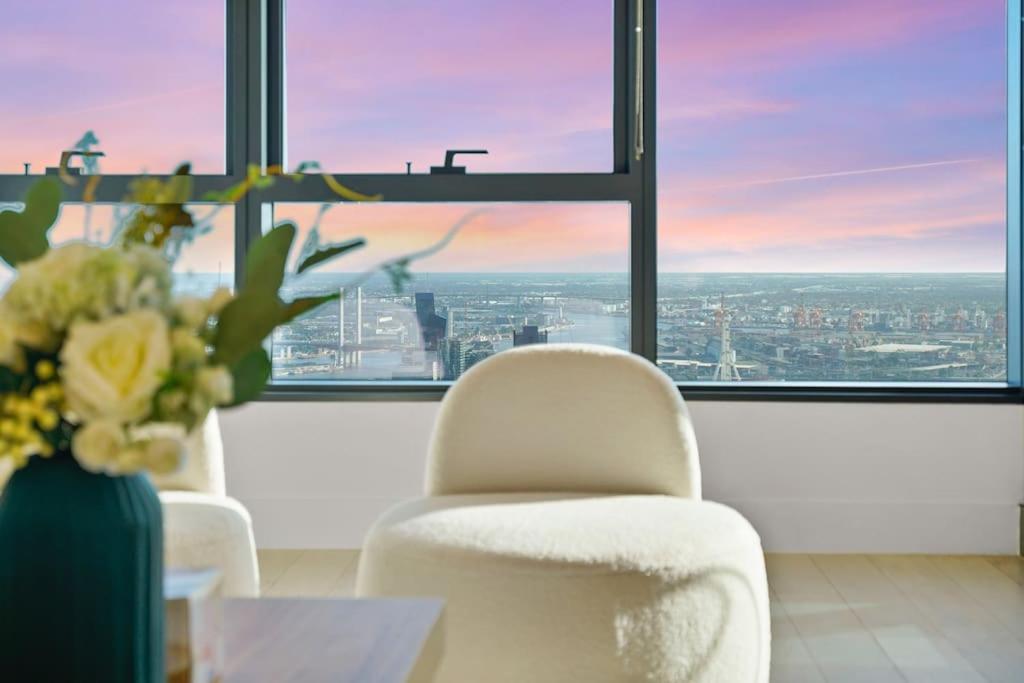 a room with two chairs and a table with a vase of flowers at Lv53 Spanning 200 degrees with no obstacle view421 in Melbourne