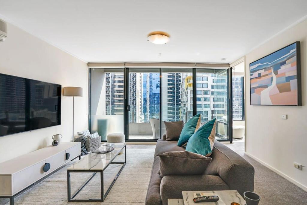 uma sala de estar com um sofá e uma televisão em Spacious&Cozy 2 bedroom City Point Melbourne Apt em Melbourne
