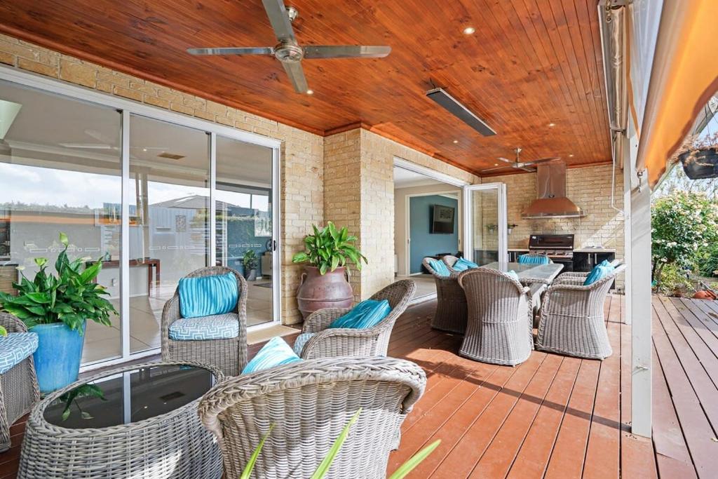 une terrasse avec des chaises en osier et une table. dans l'établissement Expansive Family Entertainer In Blue Chip Locale, à Mount Martha