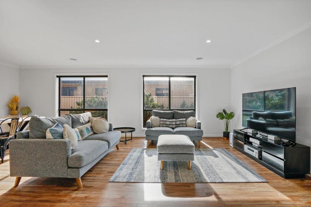 Una sala de estar con dos sofás y un televisor. en Beautiful Golden Point Home - Style&Sophistication, en Ballarat