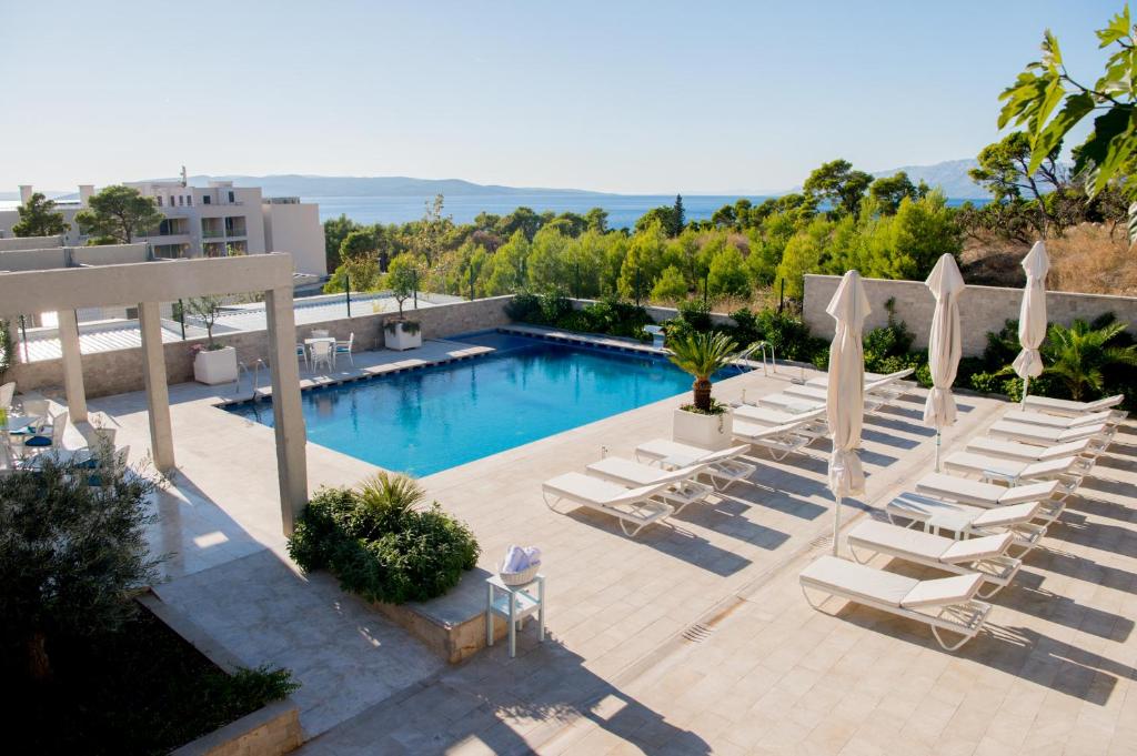 a swimming pool with lounge chairs and a swimming poolvisorvisor at Poseidon Mobile Home Resort in Makarska
