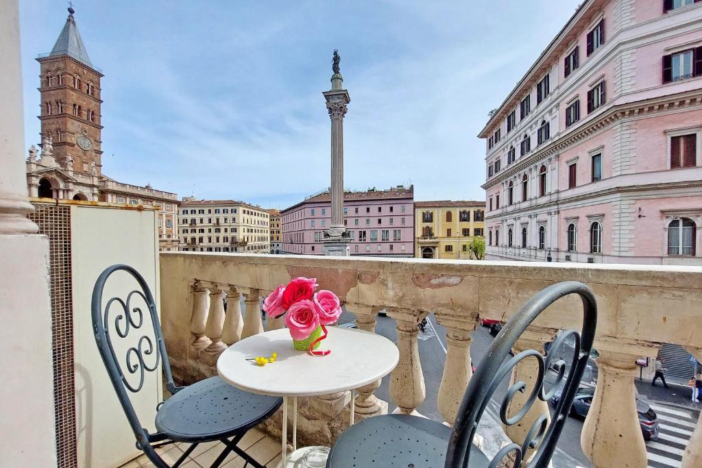 einen Tisch und Stühle auf einem Balkon mit Stadtblick in der Unterkunft Domus Maggiore in Rom