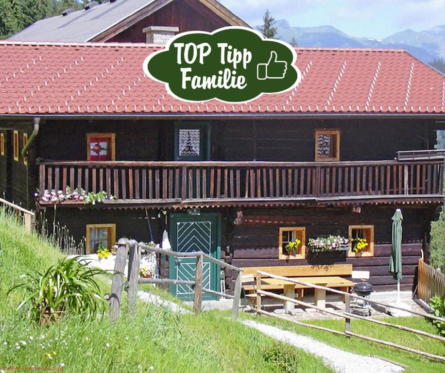 a log cabin with a top tip family sign on it at Almliesl HUET-136 in Hüttschlag