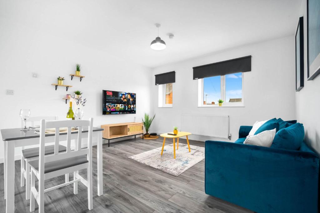 uma sala de estar com um sofá azul e uma mesa em Brand New One Bed Cradley Heath - 4MH - Parking - Netflix - Top Rated em Old Hill