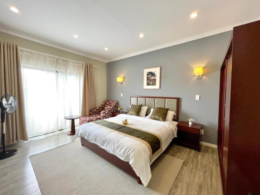 Un dormitorio con una cama grande y un sofá. en Atlantic Pearl Guest House Rivonia, en Johannesburgo
