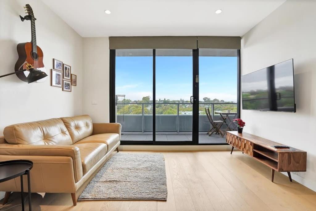 a living room with a couch and a guitar at Richmond Heritage Executive Apt for 2 w parking in Melbourne